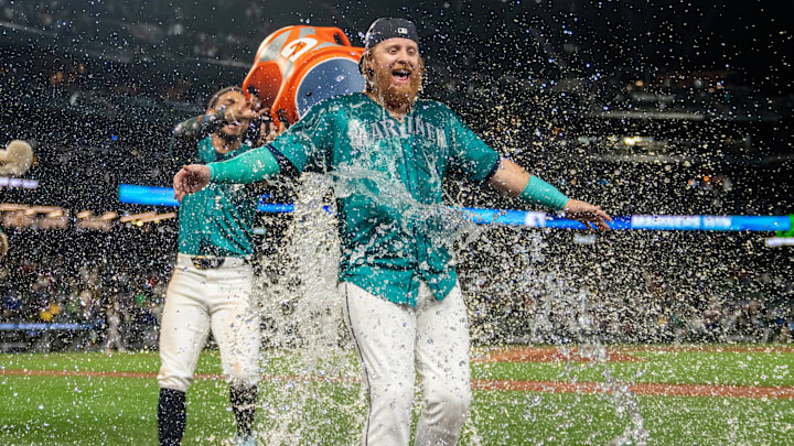 Julio Rodriguez (44), left, douses pinch hitter Justin Turner (2) with water after a game against the Oakland Athletics.
