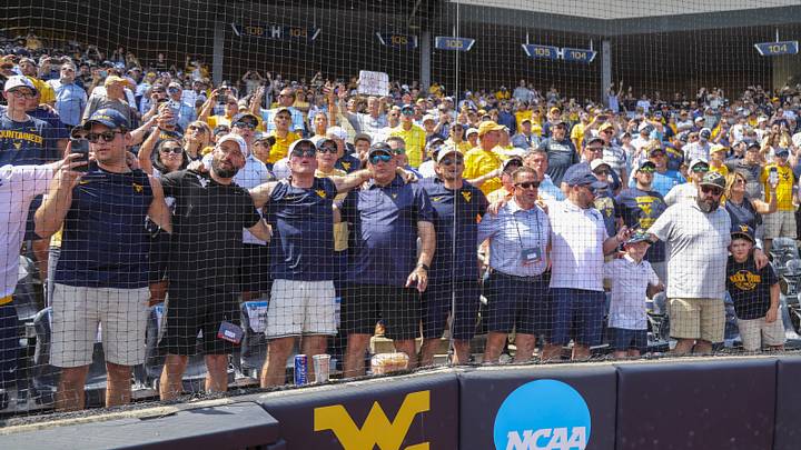 Jun 5, 2026; Morgantown, WV, USA; Pat McAfee, West Virginia head football coach Rich Rodriguez and West Virginia University President Michael Benson sing “Country Roads” after defeating the Cal Poly Mustangs at Kendrick Family Ballpark. Mandatory Credit: Ben Queen-Imagn Images Jun 5, 2026; Morgantown, WV, USA; Pat McAfee, West Virginia head football coach Rich Rodriguez and West Virginia University President Michael Benson sing “Country Roads” after defeating the Cal Poly Mustangs at Kendrick Family Ballpark. Mandatory Credit: Ben Queen-Imagn Images