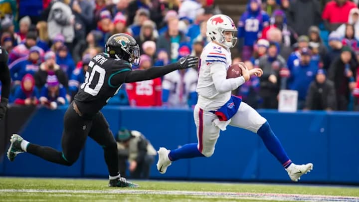 Josh Allen (#17) of the Buffalo Bills slides at the end of a run as he avoids Telvin Smith (#50) of the Jacksonville Jaguars during the second quarter at New Era Field on November 25, 2018 in Orchard Park, New York.