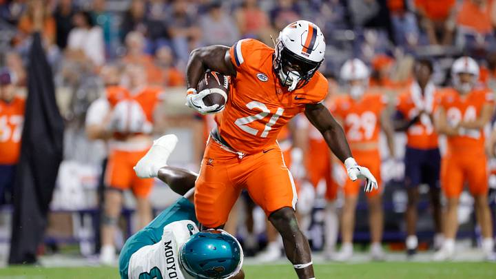 Aug 30, 2025; Charlottesville, Virginia, USA; Virginia Cavaliers running back Harrison Waylee (21) carries the ball as Coastal Carolina Chanticleers cornerback Myles Mooyoung (8) defends during the second half at Scott Stadium. Mandatory Credit: Amber Searls-Imagn Images