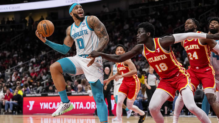 Apr 10, 2024; Atlanta, Georgia, USA; Charlotte Hornets forward Miles Bridges (0) tries to shoot over Atlanta Hawks forward Mouhamed Gueye (18) during the second half at State Farm Arena. Mandatory Credit: Dale Zanine-USA TODAY Sports