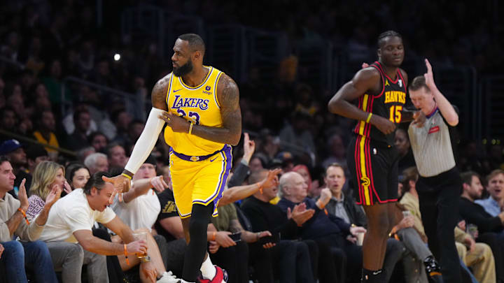 Mar 18, 2024; Los Angeles, California, USA; Los Angeles Lakers forward LeBron James (23) gestures after a three point basket against Atlanta Hawks center Clint Capela (15) in the first half at Crypto.com Arena. Mandatory Credit: Kirby Lee-Imagn Images