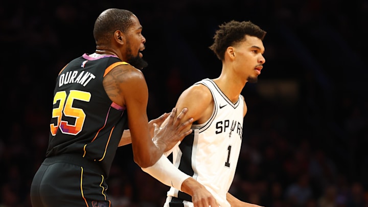 Dec 3, 2024; Phoenix, Arizona, USA; Phoenix Suns forward Kevin Durant (35) against San Antonio Spurs center Victor Wembanyama (1) in the first half of an NBA Cup game at Footprint Center. Mandatory Credit: Mark J. Rebilas-Imagn Images