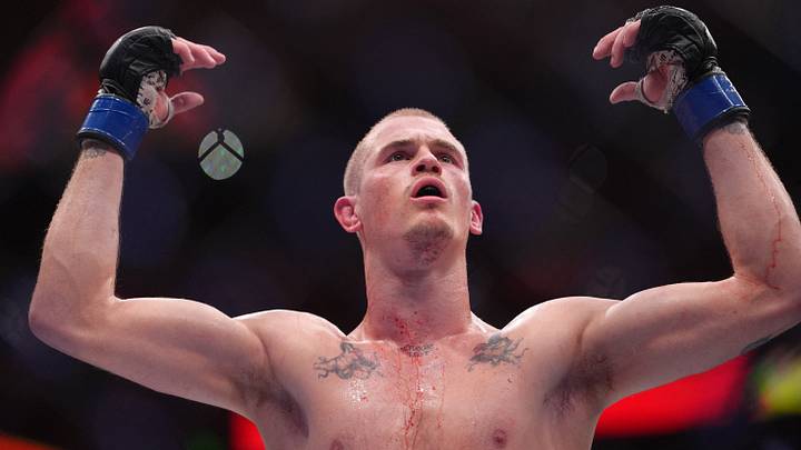 Aug 15, 2026; Philadelphia, Pennsylvania, USA; Ian Machado Garry (blue gloves)  reacts during a fight against Islam Makhachev (red gloves) in the welterweight title bout during UFC 330 at Xfinity Mobile Arena. Mandatory Credit: Kyle Ross-Imagn Images