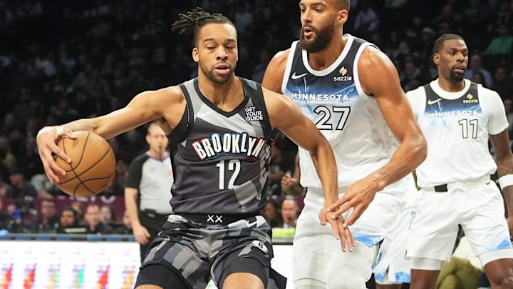 Apr 3, 2025; Brooklyn, New York, USA; Brooklyn Nets forward Tosan Evbuomwan (12) dribbles the ball against Minnesota Timberwolves center Rudy Gobert (27) during the first half at Barclays Center. Mandatory Credit: Gregory Fisher-Imagn Images