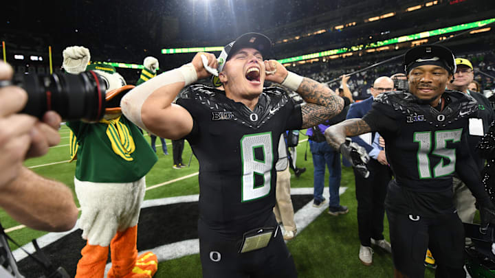 Dec 7, 2024; Indianapolis, IN, USA; Oregon Ducks quarterback Dillon Gabriel (8) and wide receiver Tez Johnson (15) celebrate defeating the Penn State Nittany Lions to win the Big Ten Championship in the 2024 Big Ten Championship game at Lucas Oil Stadium. Mandatory Credit: Robert Goddin-Imagn Images