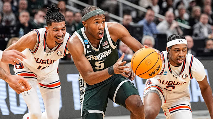 Michigan State guard Tre Holloman (5) dribbles against Auburn defenders during the South Regional final of NCAA men's tournament at State Farm Arena in Atlanta..