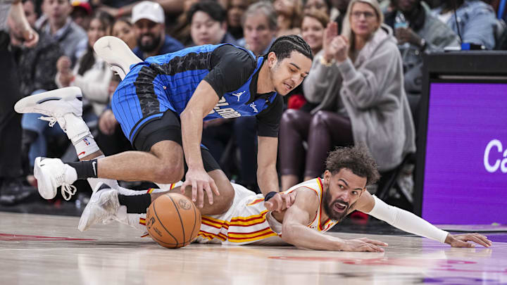 Orlando Magic guard Anthony Black (0) and Atlanta Hawks guard Trae Young (11) fight for the ball on the floor during the second half at State Farm Arena.