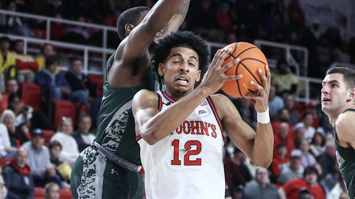 Nov 13, 2024; Queens, New York, USA;  St. John's basketball guard RJ Luis Jr. (12) drives past Wagner Seahawks forward Tyje Kelton (4) in the second half at Carnesecca Arena. Mandatory Credit: Wendell Cruz-Imagn Images