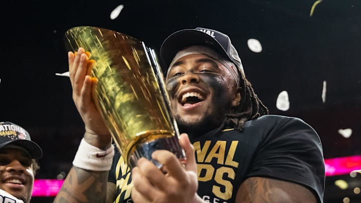 Ohio State Buckeyes defensive tackle Tyleik Williams (91) celebrates with the CFP National Championship trophy.