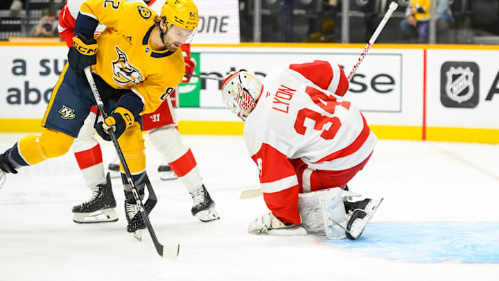 Oct 19, 2024; Nashville, Tennessee, USA;  Detroit Red Wings goaltender Alex Lyon (34) blocks the shot of  Nashville Predators center Tommy Novak (82) during the first period at Bridgestone Arena. Mandatory Credit: Steve Roberts-Imagn Images