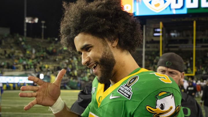 Oregon quarterback Dante Moore celebrates the Ducks' victory over James Madison at the end of the game at Autzen Stadium in Eugene Dec. 20, 2025.