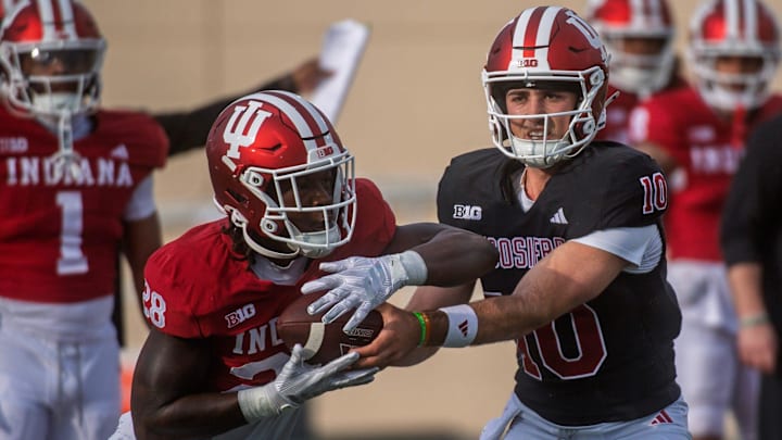 Indiana's Josh Hoover (10) hands off to Khobie Martin (28) during spring football practice at Memorial Stadium on Thursday, April 2, 2026.