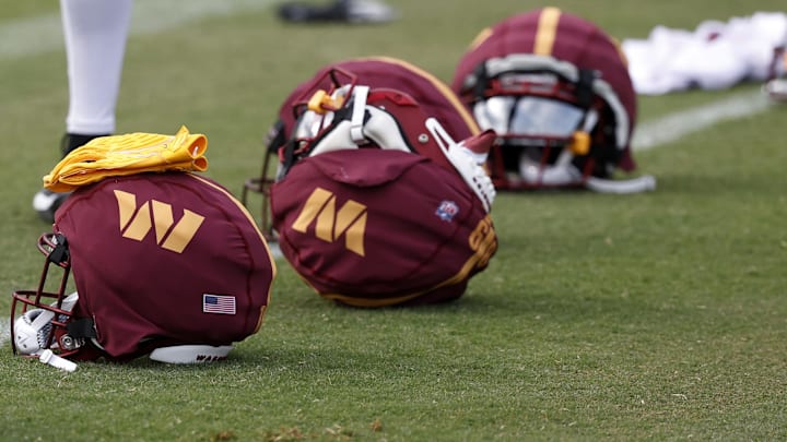 Jul 26, 2024; Ashburn, VA, USA; Washington Commanders players' helmets rest on the field on day three of training camp at Commanders Park. Mandatory Credit: Geoff Burke-Imagn Images