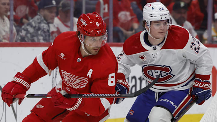Apr 15, 2024; Detroit, Michigan, USA;  Detroit Red Wings defenseman Ben Chiarot (8) skates while chased by Montreal Canadiens right wing Cole Caufield (22) in the second period at Little Caesars Arena. Mandatory Credit: Rick Osentoski-Imagn Images
