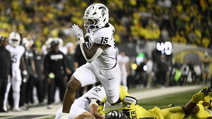 Oct 4, 2024; Eugene, Oregon, USA; Michigan State Spartans running back Kay'Ron Lynch-Adams (15) breaks away from Oregon Ducks defensive back Dakoda Fields (11) during the second half at Autzen Stadium. Mandatory Credit: Troy Wayrynen-Imagn Images
