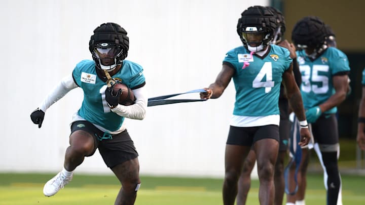 Jacksonville Jaguars running back Tank Bigsby (4) holds the elastic band attached to running back Travis Etienne Jr. (1) as they go through drills on the fifth day of the NFL football training camp practice session Monday, July 29, 2024 at EverBank Stadium's Miller Electric Center in Jacksonville, Fla.. [Bob Self/Florida Times-Union]