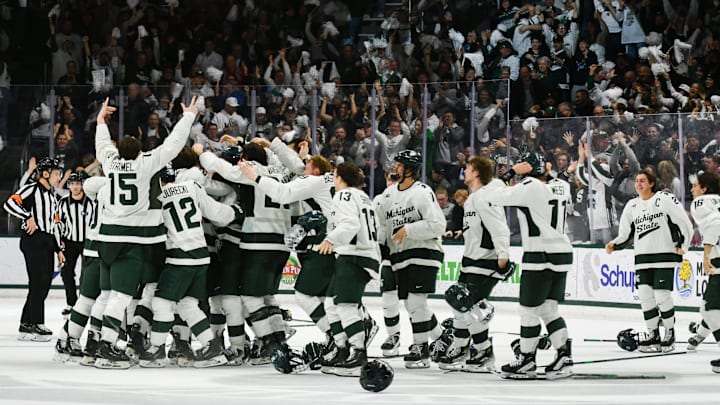 Members of the MSU Spartan hockey team celebrate their 4-3 double overtime win against Ohio State, Saturday, March 22, 2025, to win the Big 10 Hockey Championship at Munn Ice Arena.