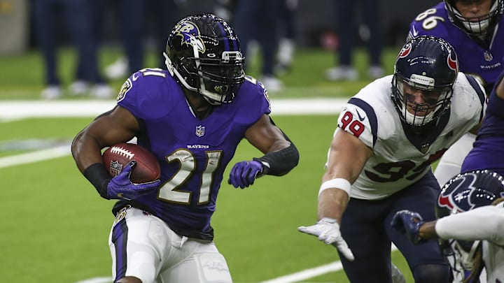 Sep 20, 2020; Houston, Texas, USA; Baltimore Ravens running back Mark Ingram (21) runs with the ball as Houston Texans defensive end J.J. Watt (99) attempts to make a tackle during the second quarter at NRG Stadium. Mandatory Credit: Troy Taormina-Imagn Images