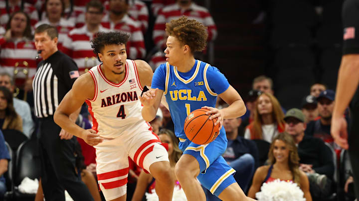 Dec 14, 2024; Phoenix, Arizona, USA; UCLA Bruins guard Trent Perry (1) against Arizona Wildcats forward Trey Townsend (4) at Footprint Center. Mandatory Credit: Mark J. Rebilas-Imagn Images