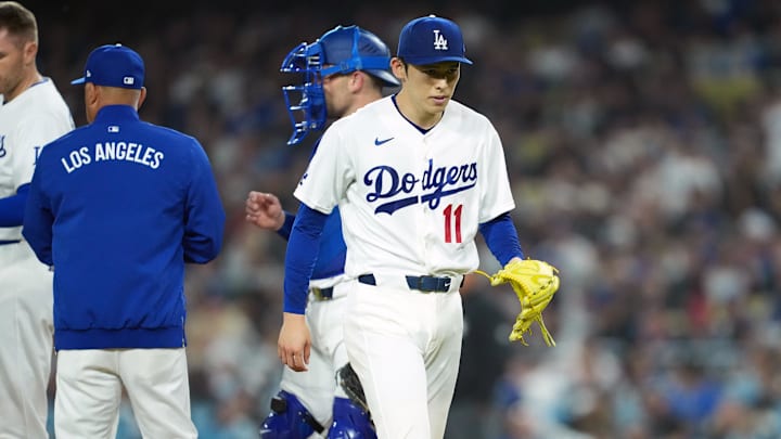 Mar 30, 2026; Los Angeles, California, USA;  Los Angeles Dodgers pitcher Roki Sasaki (11) walks back to the dugout as he is taken out from the game by manager Dave Roberts (left) during the fifth inning against the Cleveland Guardians at Dodger Stadium. Mandatory Credit: Kirby Lee-Imagn Images