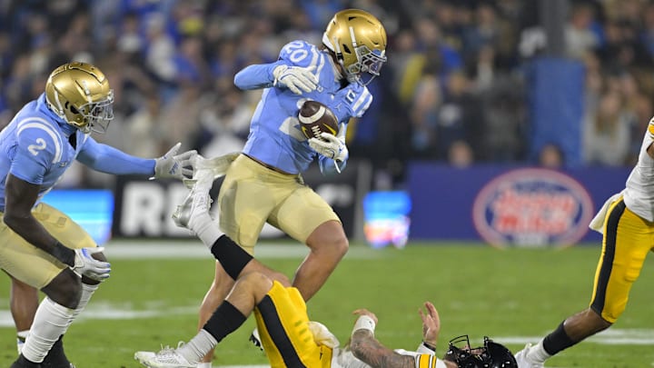 Nov 8, 2024; Pasadena, California, USA;   UCLA Bruins linebacker Kain Medrano (20) strips the ball from Iowa Hawkeyes quarterback Brendan Sullivan (1) giving the Bruins possession in the first half at the Rose Bowl. Mandatory Credit: Jayne Kamin-Oncea-Imagn Images