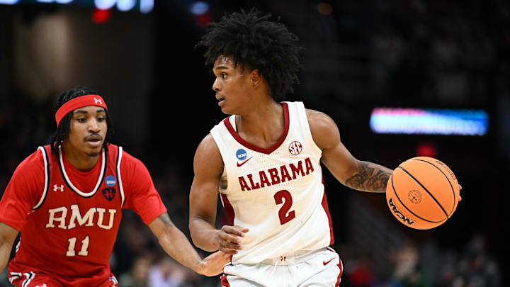 Mar 21, 2025; Cleveland, OH, USA; Alabama Crimson Tide guard Aden Holloway (2) dribbles the ball defended by Robert Morris Colonials guard DJ Smith (11) in the first half during the NCAA Tournament First Round at Rocket Arena. Mandatory Credit: Ken Blaze-Imagn Images