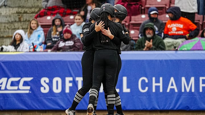 Cori McMillan (2) joins two other Hokies in an embrace. 