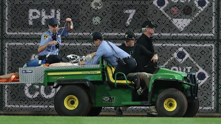 Apr 30, 2025; Pittsburgh, Pennsylvania, USA;  Stadium security and Pittsburgh Pirates medical personnel cart a fan who fell from the stands to the field to an ambulance as the Pirates batted against the Chicago Cubs during the seventh inningat PNC Park. Mandatory Credit: Charles LeClaire-Imagn Images