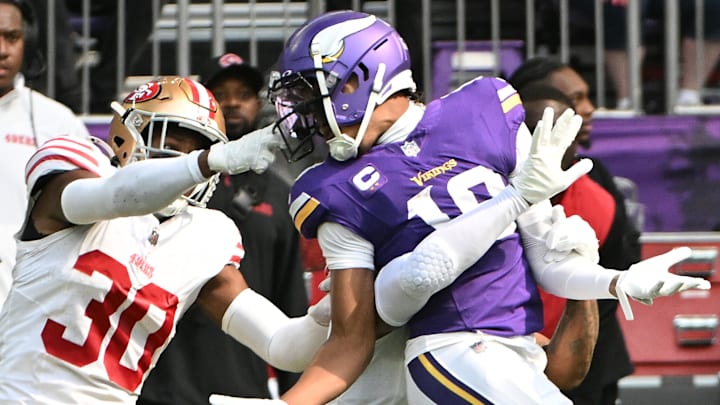 San Francisco 49ers safety George Odum (L) grabs Minnesota Vikings wide receiver Justin Jefferson (R)