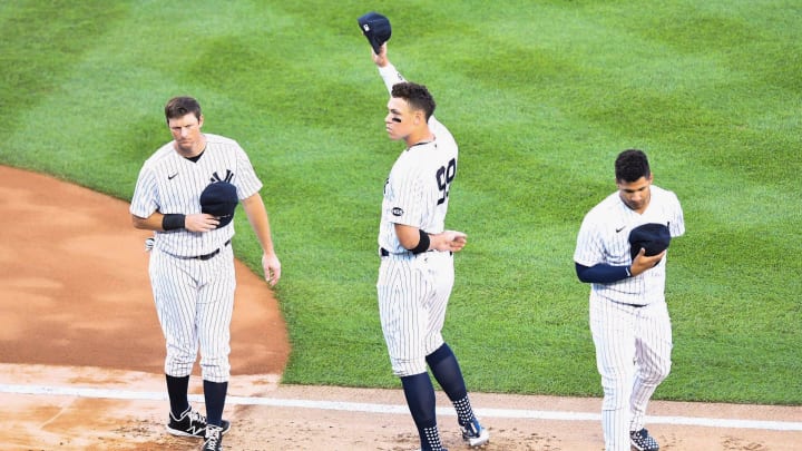 New York Yankees' Aaron Judge, center, salutes Suzyn Waldman after her singing of the national anthem before the Yankees host the Boston Red Sox on Friday, July 31, 2020, in New York. DJ LeMahieu is at left and Gleyber Torres at right.