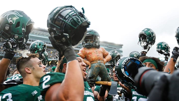 Michigan State players celebrate the 37-33 win over Michigan with the Paul Bunyan trophy at Spartan Stadium in East Lansing on Saturday, Oct. 30, 2021. Michigan State players celebrate the 37-33 win over Michigan with the Paul Bunyan trophy at Spartan Stadium in East Lansing on Saturday, Oct. 30, 2021.