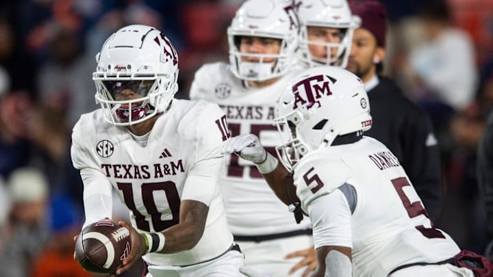Texas A&M quarterback Marcel Reed hands the ball off to running back Amari Daniels during warmups before the Aggies' game against Auburn on Nov. 23, 2024, in Auburn, Ala.