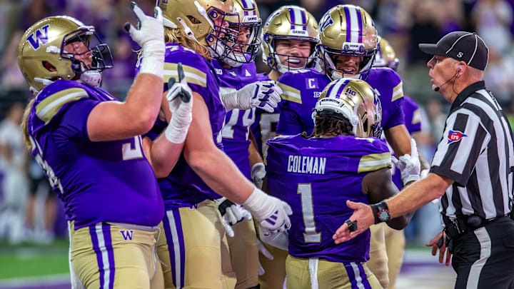 The Husky offensive line surrounds Jonah Coleman after one of his seven touchdowns. 