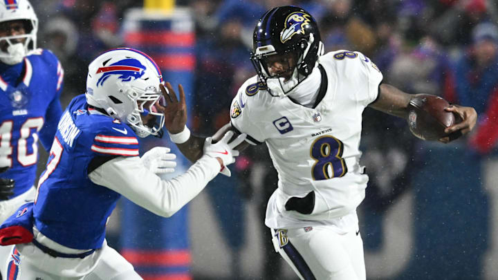 Jan 19, 2025; Orchard Park, New York, USA; Baltimore Ravens quarterback Lamar Jackson (8) runs the ball against Buffalo Bills cornerback Taron Johnson (7) during the first quarter in a 2025 AFC divisional round game at Highmark Stadium. Mandatory Credit: Mark Konezny-Imagn Images