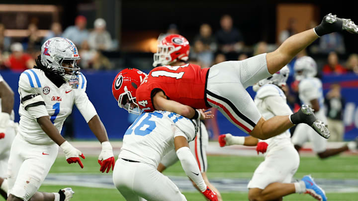 Jan 1, 2026; New Orleans, LA, USA; Mississippi Rebels safety Wydett Williams Jr. (16) tackles Georgia Bulldogs quarterback Gunner Stockton (14) in the third quarter during the 2026 Sugar Bowl and quarterfinal game of the College Football Playoff at Caesars Superdome. Mandatory Credit: Geoff Burke-Imagn Images