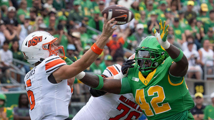 Oregon defensive lineman Aydin Breland, right, pressures Oklahoma State quarterback Zane Flores, left, during the second quarter at Autzen.