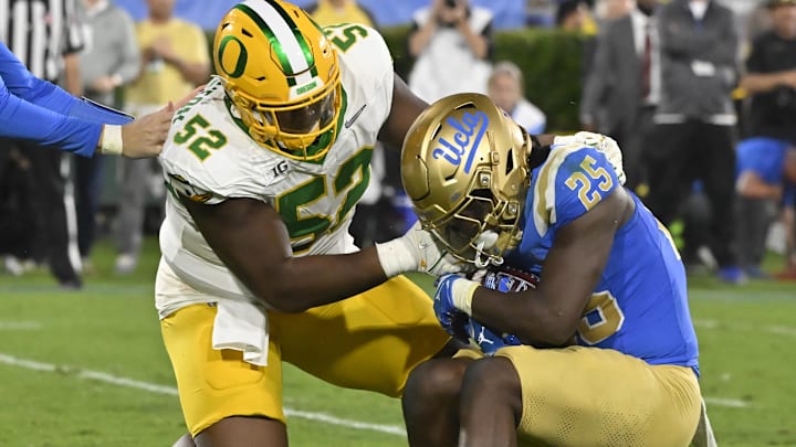 Sep 28, 2024; Pasadena, California, USA; Oregon Ducks defensive lineman A'Mauri Washington (52) tackles UCLA Bruins running back T.J. Harden (25) in the backfield during the third quarter at Rose Bowl. Mandatory Credit: Robert Hanashiro-Imagn Images