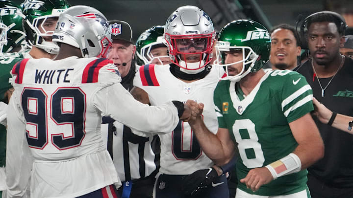 Sep 19, 2024; East Rutherford, New Jersey, USA; New York Jets quarterback Aaron Rodgers (8) bumps fists with New England Patriots defensive end Keion White (99) after Rogers was tackled on the sidelines by White in the second half at MetLife Stadium. Mandatory Credit: Robert Deutsch-Imagn Images Sep 19, 2024; East Rutherford, New Jersey, USA; New York Jets quarterback Aaron Rodgers (8) bumps fists with New England Patriots defensive end Keion White (99) after Rogers was tackled on the sidelines by White in the second half at MetLife Stadium. Mandatory Credit: Robert Deutsch-Imagn Images