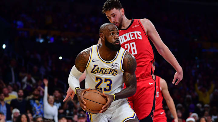 Dec 25, 2025; Los Angeles, California, USA; Los Angeles Lakers forward LeBron James (23) moves the ball ahead of Houston Rockets center Alperen Sengun (28) during the first half at Crypto.com Arena. Mandatory Credit: Gary A. Vasquez-Imagn Images