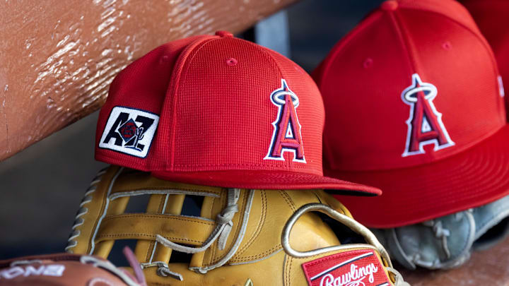 Feb 28, 2025; Phoenix, Arizona, USA; Detailed view of the Los Angeles Angels logo on a hat in the dugout during a spring training game at Camelback Ranch-Glendale. Mandatory Credit: Mark J. Rebilas-Imagn Images