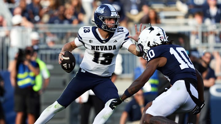 Aug 30, 2025; University Park, Pennsylvania, USA; Nevada Wolf Pack quarterback Chubba Purdy (13) scrambles with the ball while trying to avoid a tackle by Penn State Nittany Lions safety Dejuan Lane (10) during the third quarter at Beaver Stadium. Penn State defeated Nevada 46-9. Mandatory Credit: Matthew O'Haren-Imagn Images