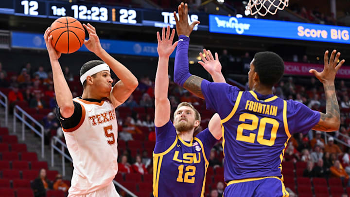 Dec 16, 2023; Houston, Texas, USA; Texas Longhorns forward Kadin Shedrick (5) looks to pass the ball against LSU Tigers forward Hunter Dean (12) and forward Derek Fountain (20) during the first half at Toyota Center. Mandatory Credit: Maria Lysaker-Imagn Images