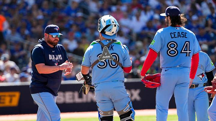 Toronto Blue Jays manager John Schneider walks to the mound to relieve Toronto Blue Jays pitcher Dylan Cease.