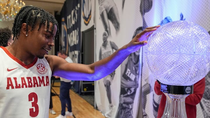 Alabama player Latrell Wrightsell lays a hand on the NABC Coach’s Trophy during SEC Media Day at the Grand Bohemian Hotel in Mountain Brook Tuesday, Oct. 15, 2024.