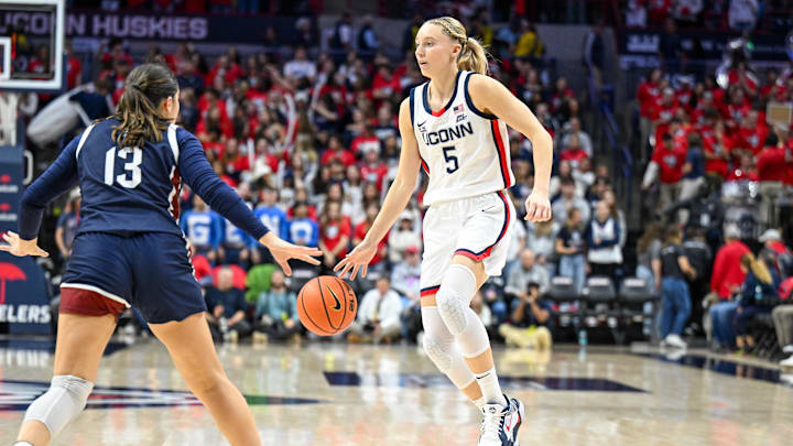 Nov 20, 2024; Storrs, Connecticut, USA; Connecticut Huskies guard Paige Bueckers (5) dribbles the ball defended by Fairleigh Dickinson Knights guard Abaigeal Babore (13) during the second half at Harry A. Gampel Pavilion. Mandatory Credit: Mark Smith-Imagn Images Nov 20, 2024; Storrs, Connecticut, USA; Connecticut Huskies guard Paige Bueckers (5) dribbles the ball defended by Fairleigh Dickinson Knights guard Abaigeal Babore (13) during the second half at Harry A. Gampel Pavilion. Mandatory Credit: Mark Smith-Imagn Images
