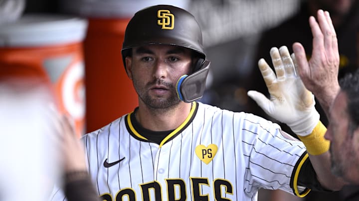Aug 24, 2024; San Diego, California, USA; San Diego Padres catcher Kyle Higashioka (20) is congratulated in the dugout after scoring a run during the fifth inning against the New York Mets at Petco Park