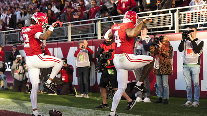 Nov 30, 2024; Tuscaloosa, Alabama, USA;  Alabama Crimson Tide quarterback Jalen Milroe (4) celebrates with wide receiver Ryan Williams (2) after scoring a touchdown against the Auburn Tigers during the first half at Bryant-Denny Stadium. Mandatory Credit: Gary Cosby Jr.-Imagn Images