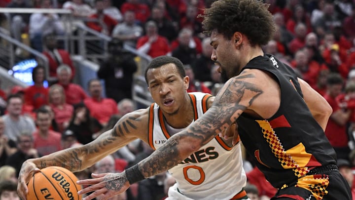 Feb 8, 2025; Louisville, Kentucky, USA;  Miami (Fl) Hurricanes guard Matthew Cleveland (0) drives to the basket against Louisville Cardinals guard J'Vonne Hadley (1) during the first half at KFC Yum! Center. Louisville defeated Miami 88-78. Mandatory Credit: Jamie Rhodes-Imagn Images