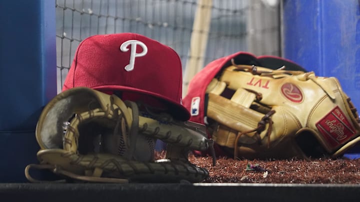 Aug 16, 2023; Toronto, Ontario, CAN; A Philadelphia Phillies cap and glove sit in the dugout during a game against the Toronto Blue Jays at Rogers Centre. Mandatory Credit: John E. Sokolowski-Imagn Images Aug 16, 2023; Toronto, Ontario, CAN; A Philadelphia Phillies cap and glove sit in the dugout during a game against the Toronto Blue Jays at Rogers Centre. Mandatory Credit: John E. Sokolowski-Imagn Images